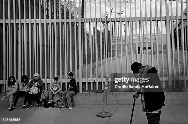Pedestrians wait in line to cross the U.S.-Mexico border in Tijuana, Mexico on Sunday, March 3, 2013. Due to the recent Sequestration cuts, Customs...