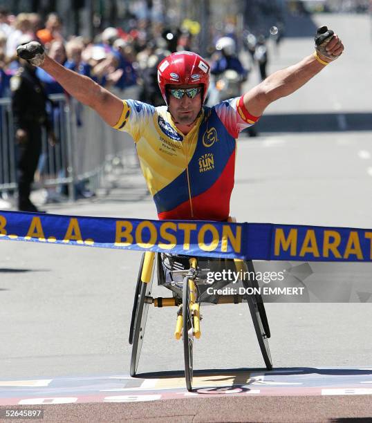 Ernst Van Dyk of South Africa raises his arms as he crosses the finish line to win the men's wheelchair race of the 109th running of the Boston...