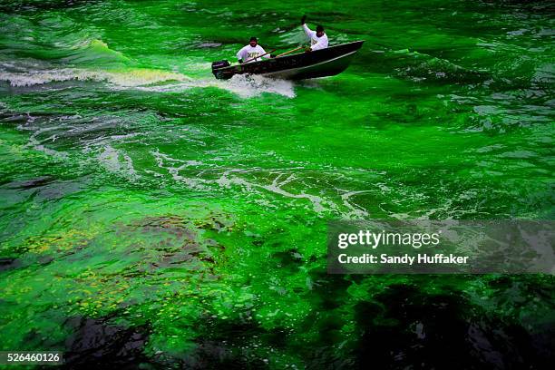 Workers ride by after pouring Green dye in the Chicago River during a St Patricks Day paraden in Chicago, IL on Saturday, March 16, 2013. There was...