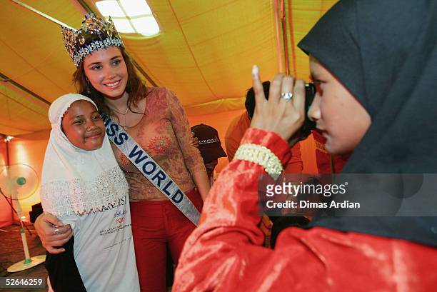 Miss World 2004, Maria Julia Mantilla Garcia, of Peru poses with a local child during an emotional visit to Indonesia's devastated Banda Aceh at a...