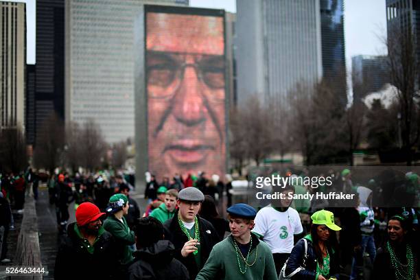 Party-goers walk along Millenium Park during a St Patricks Day paraden in Chicago, IL on Saturday, March 16, 2013. There was Green beer, Irish folk...