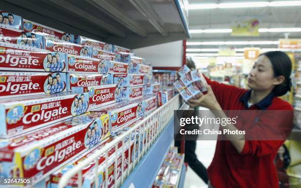 A shop assistant removes Colgate toothpaste from the shelves of a ...
