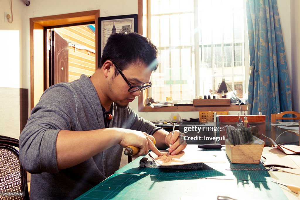 Chinês leatherworker trabalhar na pele padrão