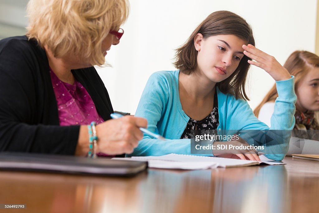 Teacher talking to upset student during detention in school