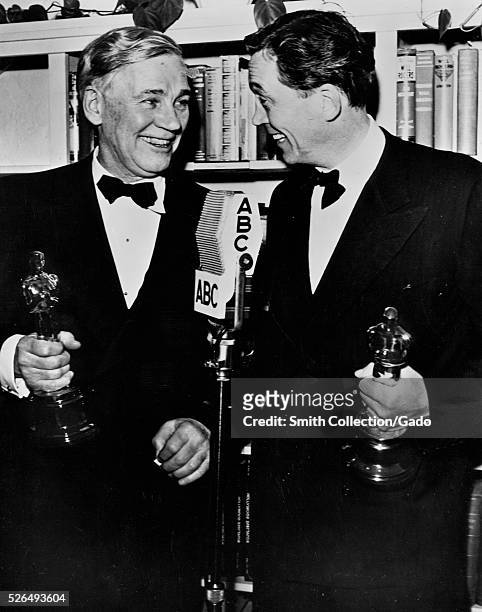 Walter Huston and his son, John Huston, exchange congratulations after they won academy awards for their work in "Treasure of the Sierra Madre",...