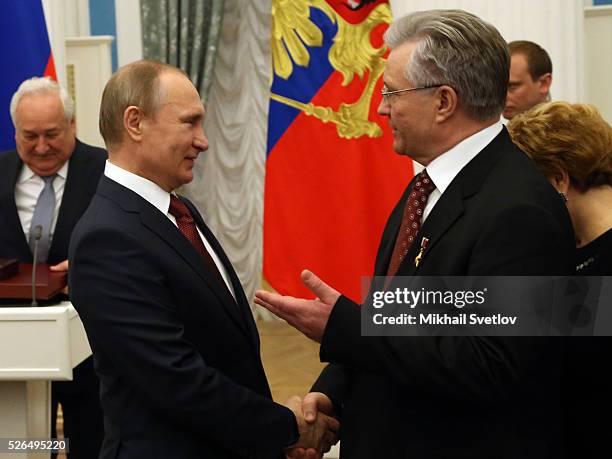 Russian President Vladimir Putin greets President of Surgutneftegas Vladimir Bogdanov during the awarding ceremony at the Kremlin April 2016 in...