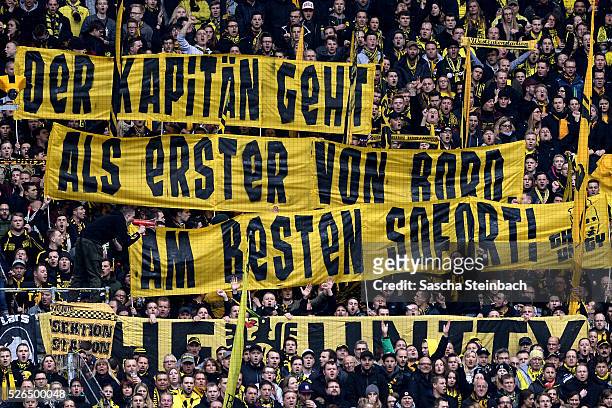 Fans in the Dortmund stand show a banner "Der Kapitaen geht als erster von Bord. Am besten sofort!" according to Mats Hummels during the Bundesliga...