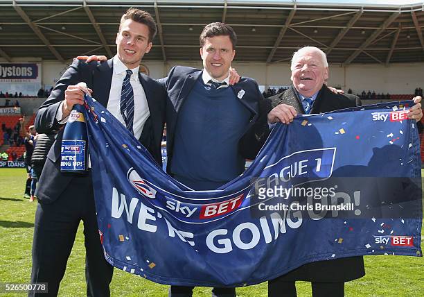 Wigan Athletic chairman David Sharpe, manager Gary Caldwell and owner Dave Whelan celebrate promotion to the Championship after the Sky Bet League...