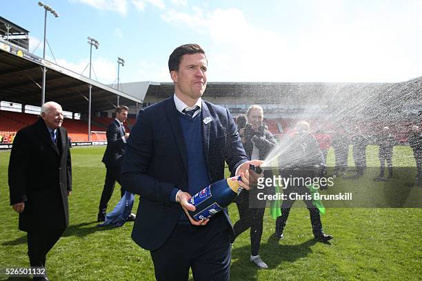 Wigan Athletic manager Gary Caldwell sprays champagne as they celebrate promotion to the Championship after the Sky Bet League One match between...