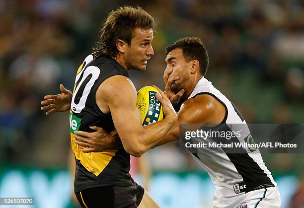 Ivan Maric of the Tigersis tackled by Brendon Ah Chee of the Power during the 2016 AFL Round 06 match between the Richmond Tigers and Port Adelaide...