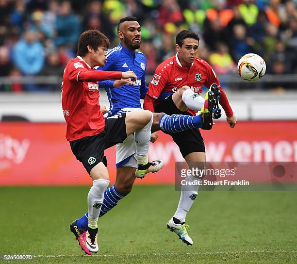 Eric Maxim Choupo-Moting of Schalke is challenged by Hiroki Sakai and Manuel Schmiedebach of Hannover during the Bundesliga match between Hannover 96...