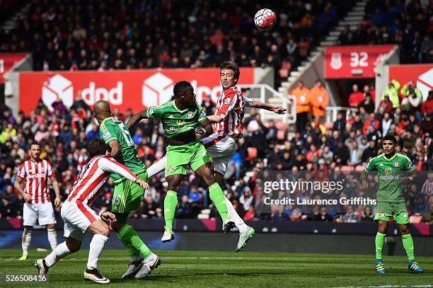 Peter Crouch of Stoke City outjumps Lamine Kone of Sunderland during the Barclays Premier League match between Stoke City and Sunderland at The...