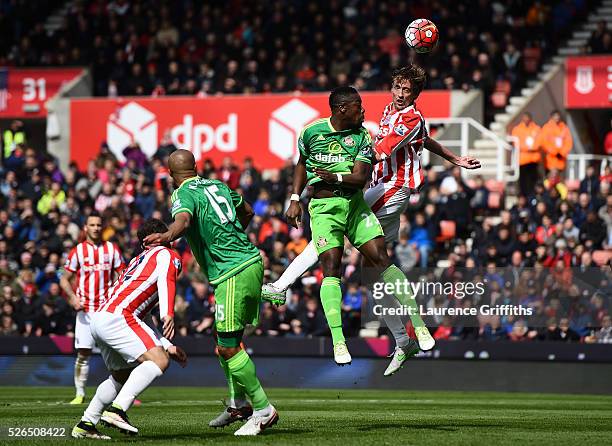 Peter Crouch of Stoke City outjumps Lamine Kone of Sunderland during the Barclays Premier League match between Stoke City and Sunderland at The...