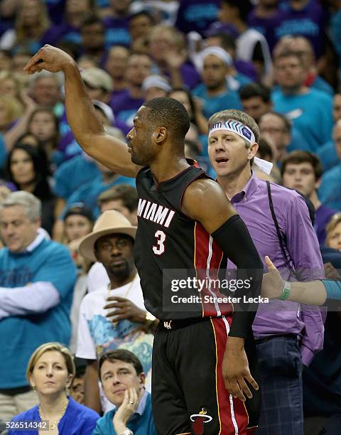 Dwyane Wade of the Miami Heat reacts after making a shot late in the fourth quarter against the Charlotte Hornets during game six of the Eastern...