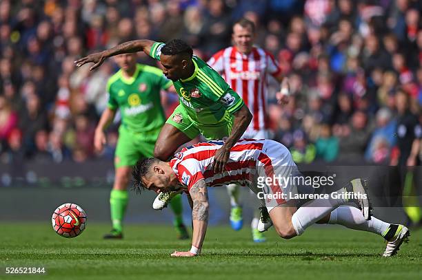 Jermain Defoe of Sunderland and Geoff Cameron of Stoke City compete for the ball during the Barclays Premier League match between Stoke City and...