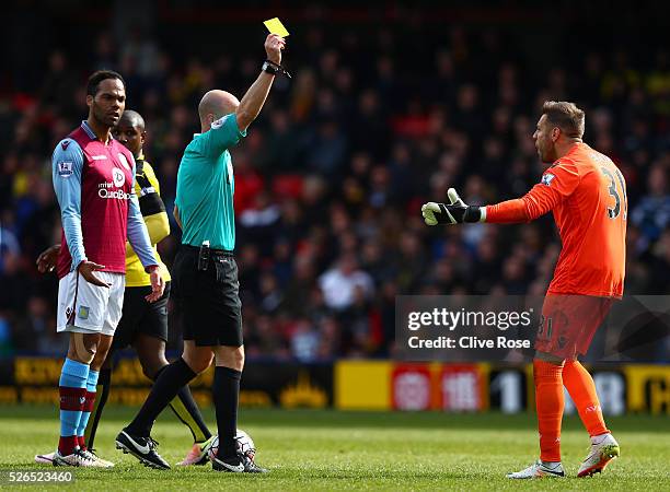 Mark Bunn of Aston Villa is shown a yellow card by referee Anthony Taylor during the Barclays Premier League match between Watford and Aston Villa at...