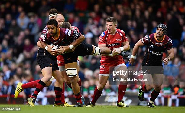 Taulupe Faletau is tackled by Scott Williams of the Scarlets during the Guinness Pro 12 match between Newport Gwent Dragons and Scarlets at...