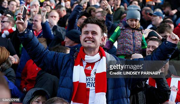 Sunderland fans celebrate after English forward Jermain Defoe scored the equalising 1-1 goal during the English Premier League football match between...