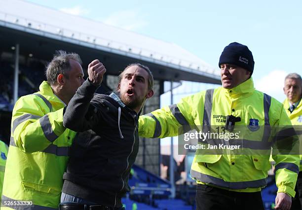 Stewards remove a fan from the pitch during the Barclays Premier League match between Everton and A.F.C. Bournemouth at Goodison Park on April 30,...