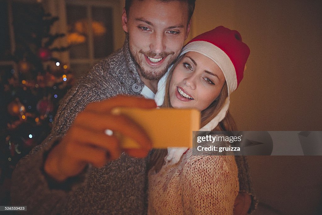 Young couple in love is making selfie on Christmas night