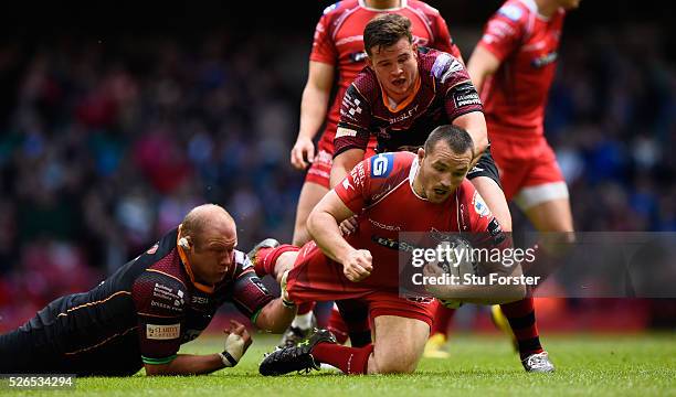 Ken Owens of the Scarlets breaks the tackle of Brok Harris of Newport during the Guinness Pro 12 match between Newport Gwent Dragons and Scarlets at...