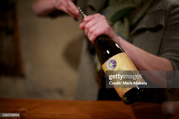 Cellar Master Casey Economides uncorks a bottle of wine at Amalthea Cellars winery in Atco, NJ on March 21, 2013.