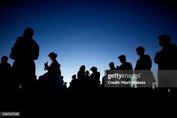 Reenactors congregate outside the tent in a break from a Saturday night dance, as a woman is illuminated by the light of her cellphone, on the third...