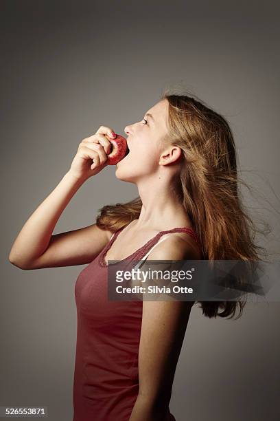 15 year old girl biting into an apple - 15 year old blonde girl fotografías e imágenes de stock