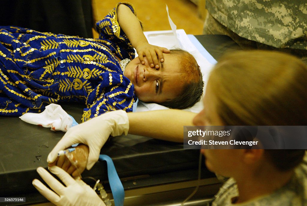 Afghan child reacts to drip needle inserted in arm