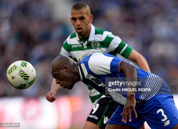 Porto's Dutch defender Bruno Martins Indi heads the ball next to Sporting's Algerian forward Islam Slimani during the Portuguese league football...