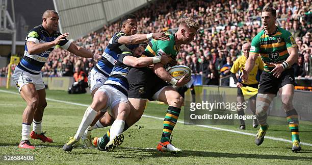 Harry Mallinder of Northampton is tackled by Jeff Williams and Anthony Watson during the Aviva Premiership match between Northampton Saints and Bath...
