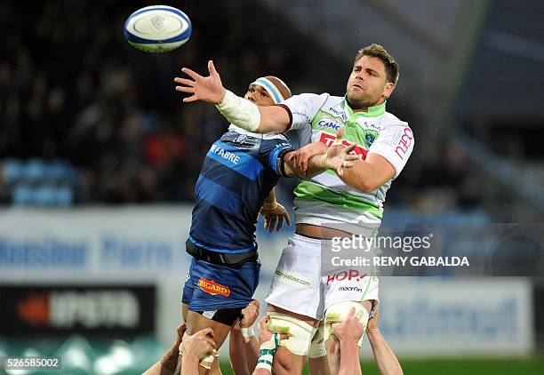 Pau's lock Claude Dry grabs the ball in a line out next to Castres's Alexandre Bias during the French Top 14 Rugby Union match Castres vs Pau at the...