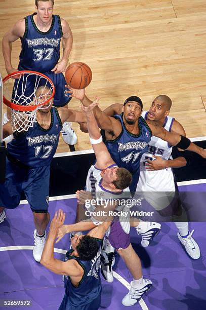 Eddie Griffin of the Minnesota Timberwolves goes up to make a block between Darius Songaila and Corliss Williamson of the Sacramento Kings during a...