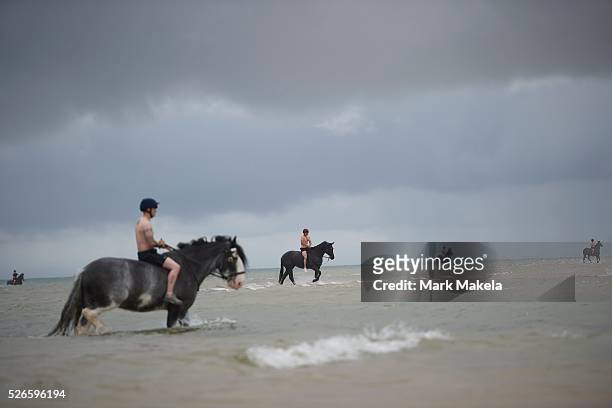 Members of the Household Cavalry, the Queen of England's mounted horsemen, swim with their horses in the Holkham Beach sea in Wells-next-the-Sea,...
