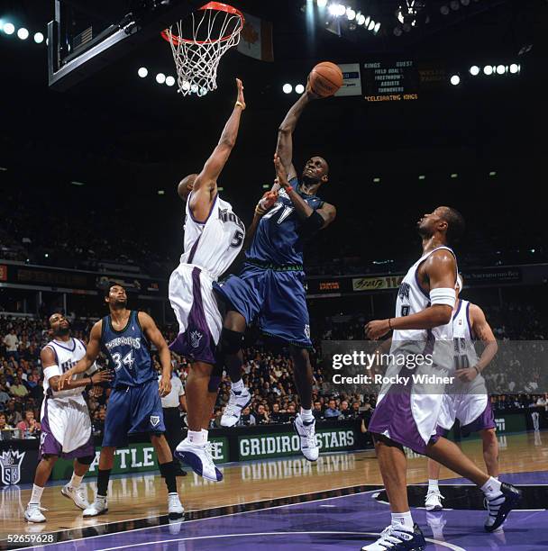 Kevin Garnett of the Minnesota Timberwolves takes the ball to the basket against Brian Skinner of the Sacramento Kings during a game at Arco Arena on...