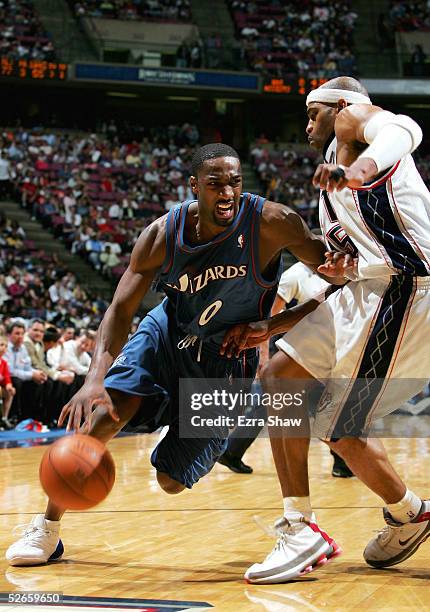 Gilbert Arenas of the Washington Wizards drives past Vince Carter of the New Jersey Nets on April 19, 2005 at Continental Airlines Arena in East...