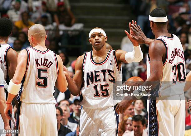 Vince Carter is congratulated by teammates Jason Kidd and Clifford Robinson of the New Jersey Nets after he is fouled in the third quarter of their...