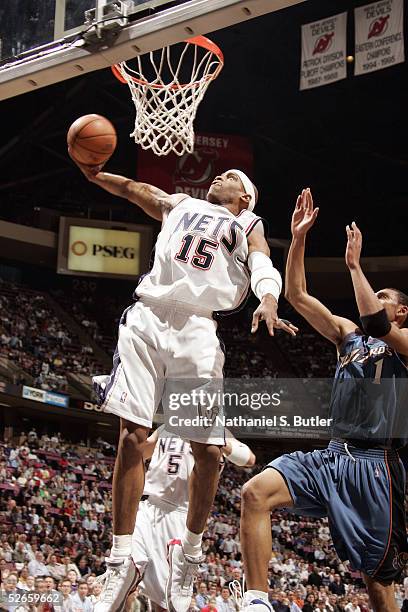 Vince Carter of the New Jersey Nets drives to the hoop as Jared Jeffries of the Washington Wizards defends on April 19, 2005 at the Continental...