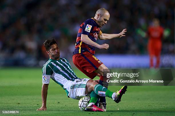 Andres Iniesta of FC Barcelona is tackled by Alvaro Cejudo of Real Betis Balompie during the La Liga match between Real Betis Balompie and FC...