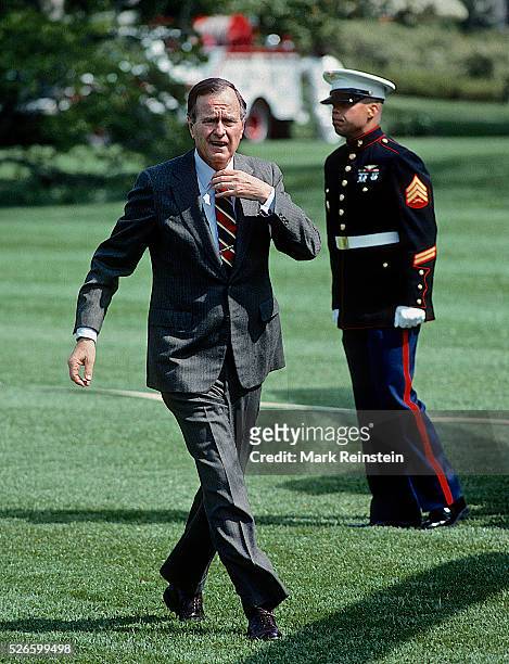 Washington, DC April-1989 President George H. W. Bush waves to the press as he walks towards the Oval Office from Marine One after landing on the...