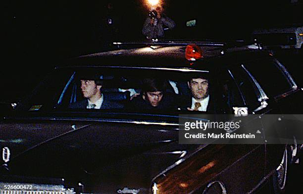 Washington, DC. 3-30-1981 John Hinckey Jr. Sits in the middle of the bench seat of the station surrounded by FBI agents departs the United States...