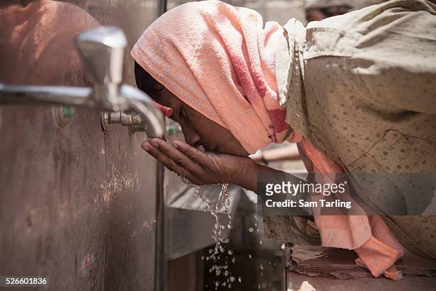 Migrant construction worker from Sri Lanka uses an open air wash-room in the scorching summer heat at a workers' camp in al-Khor, Qatar, on June 17,...