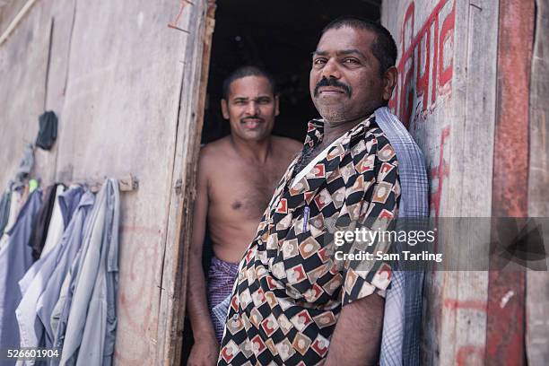 Migrant workers stand in the doorway of their shared bedroom at a workers' camp in al-Khor, Qatar, on June 17, 2011. According to the advocacy group...