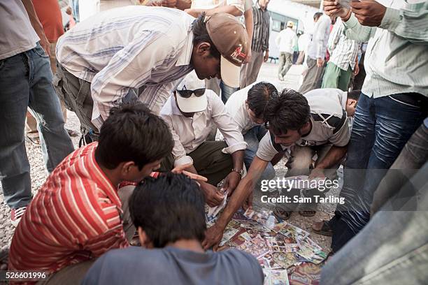 Migrant workers gather on "Bank Street," in downtown Doha on June 17 where many workers wire remittance money to their families in their home...