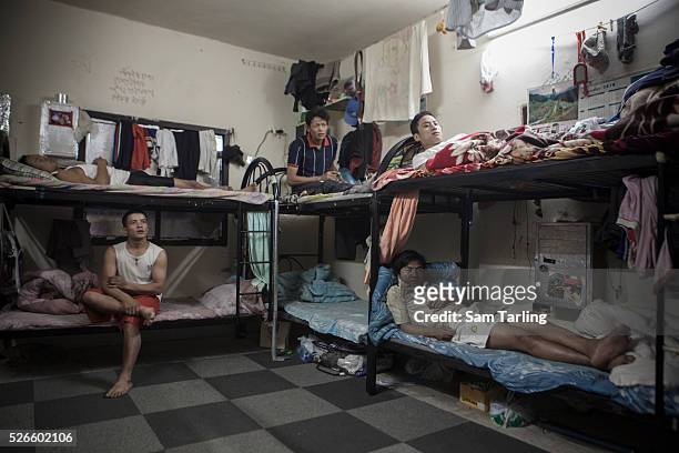 Nepali migrant workers rest after a day of work on foam mattresses, between 1 and 8 centimeters thick in a labor camp dormitory in Doha's Industrial...