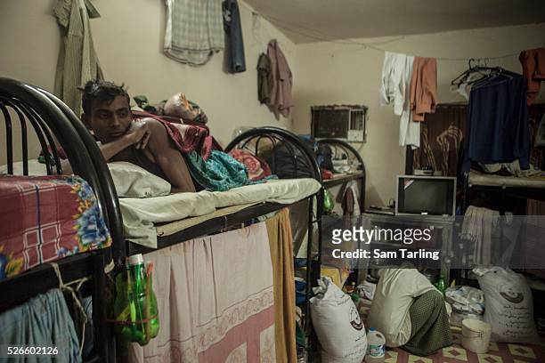 Migrant workers rest after a day of work on foam mattresses, between 1 and 8 centimetres thick, in a labor camp dormitory in Doha's Industrial Area,...