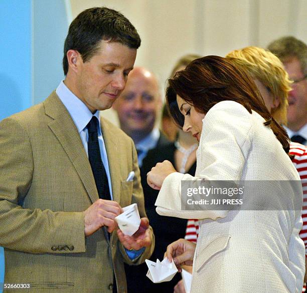 Denmark's Crown Prince Frederik Andre Henrik Christian and Australian-born Crown Princess Mary try to make paper ships as part of their visit to the...
