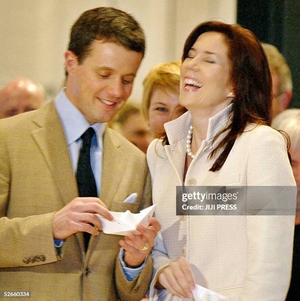 Denmark's Crown Prince Frederik Andre Henrik Christian try to make a paper ship while his wife Crown Princess Mary laughes as part of their visit to...