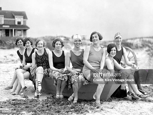 Young flappers gather around on the sandy shore of an East Coast USA beach.