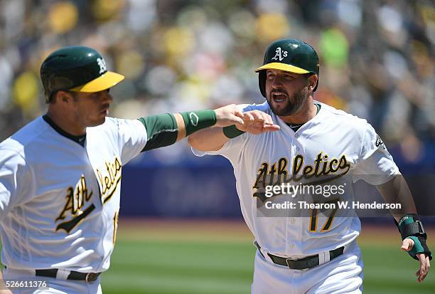 Josh Phegley and Yonder Alonso of the Oakland Athletics celebrates after they both scored against the Houston Astros in the bottom of the second...